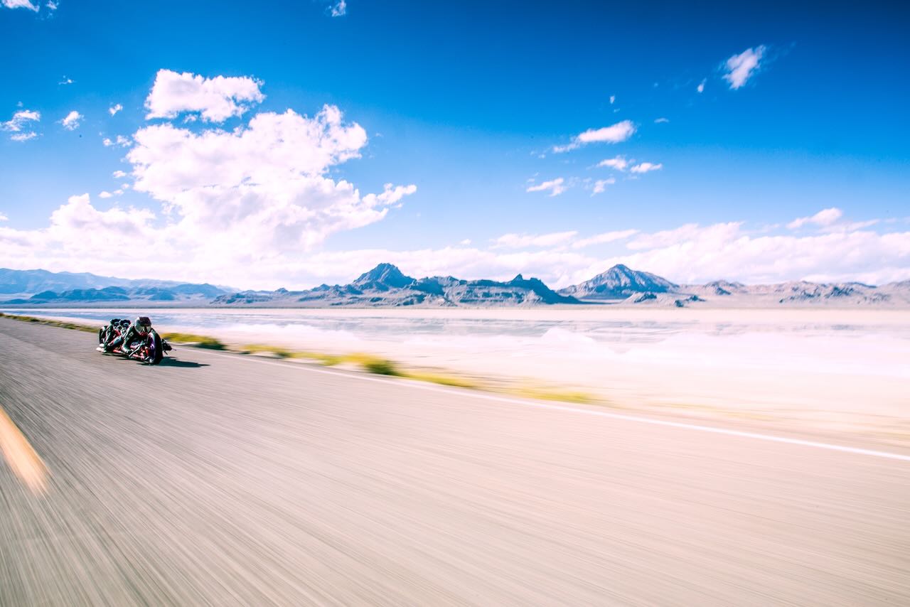 Drag race motorcycle on a road with mountains and blue sky in the background