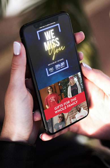 phone in the hands of a woman with a email on screen that says we miss you 20% off and gifts for the whole family