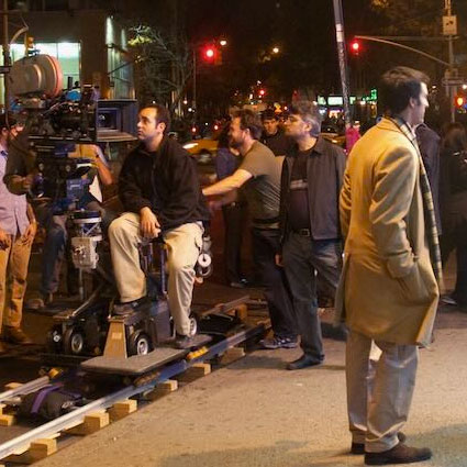 production of When Harry Tries to Marry in a city with camera operator and director in the background