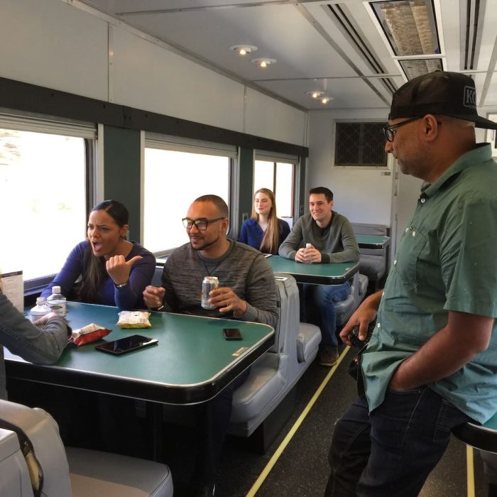 Director conversing with talent on a train